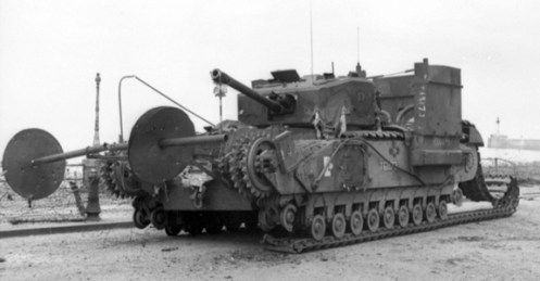 T68173 Cougar, a Churchill Mk III of No. 13 Troop, “C” Squadron, The Calgary Regiment, one of the five tanks fitted with the “Beach Track Laying Device,” for the landings at Dieppe on 19 August 1942. Having only jettisoned part of its beach track laying device, the remains of it are clearly visible on her front. Notice how the two short brackets carried the spindle, and that the inside and outside 3 foot diameter, 14 gauge metal disc shields, that prevented the chespaling from fouling the brackets and spindle, have closed up on themselves. Note also, the remains of the rigid conduit, on her right side, that had to be added for the protection of the wiring for the electrically fired small explosive charges, that released the rolls, and for those that jettisoned the whole device. Source: Authors’ collection.