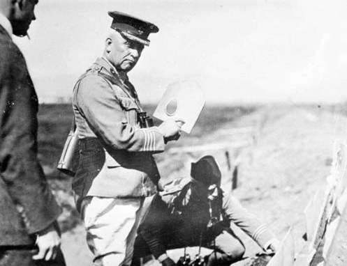 Sir Samuel Hughes holding a MacAdam Shield Shovel. PA-202396