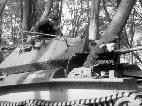 T18368, a Covenanter I, which was issued to Headquarters, 1st Canadian Army Tank Brigade, on 5 August 1941, taking part in the filming of a British Military Training Film, entitled ‘Ten Tips for Tackling Tanks,’ in the fall of 1941, for which the crew is dressed as a German tank crew. The Covenanter driver’s compartment was notably cramped, as is illustrated here, note, there isn’t too much room between the driver, who is leaning on the folded down hinged front section, and the hinged two-piece rear section, of his hatch. Note the short pipe, on the turret side, just behind the driver, this was for the barrel of the anti-aircraft/ground defence .303-inch Bren light machine gun, to rest on when connected to its Lakeman anti-aircraft mount (a portion of which is visible), when not in use. The number ‘2,’ which appears midway along the turret side, indicates, that this is the number two tank of brigade headquarters (see the next caption for details). Source: authors’ collection.