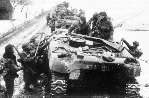 Infantrymen of the 2nd Battalion, Devonshire Regiment, of 131st British Infantry Brigade, loading onto ‘Ram’ Kangaroo armoured personnel carriers of “B” Squadron, 1st Canadian Armoured Personnel Carrier Regiment, near Dieteren, Holland, on 15 January 1945, during Operation BLACKCOCK. Note that the crew of the ‘Kangaroo’ in the foreground has left their pioneer tools strapped in place on the rear deck, common practice within the Regiment was to remove these, so that their infantry passengers wouldn’t make off with them for their own use. Source: Bovington Tank Museum (BTM 2293-A5)