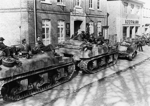 BUCKSHEE and another ‘Ram’ Kangaroo armoured personnel carrier of “B” Squadron, 1st Canadian Armoured Personnel Carrier Regiment, with infantrymen of “A” Company, The Argyll & Sutherland Highlanders of Canada (Princess Louise’s), 10th Canadian Infantry Brigade, in Werlte, Germany, on 11 April 1945. Note the track extended end connectors on the outside edge of the right track, of both ‘Kangaroos’, and also the position of the secondary .30-calibre Browning machine gun mounted in the turret ring. Source: MilArt photo archives